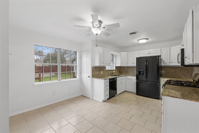 kitchen featuring white cabinetry, dark stone countertops, backsplash, and black appliances