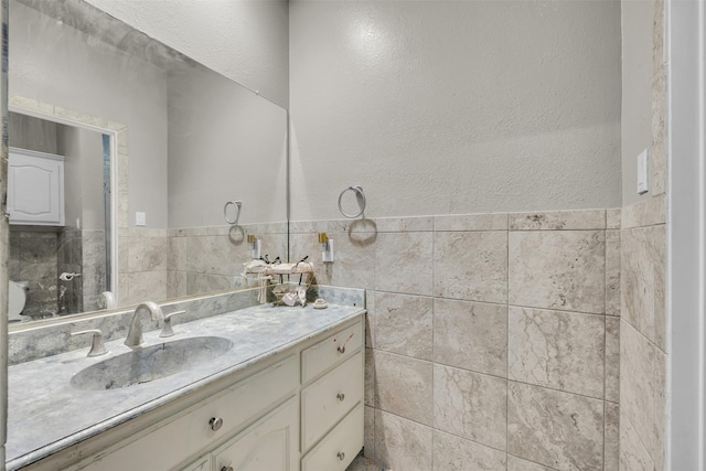 bathroom with vanity and tile walls