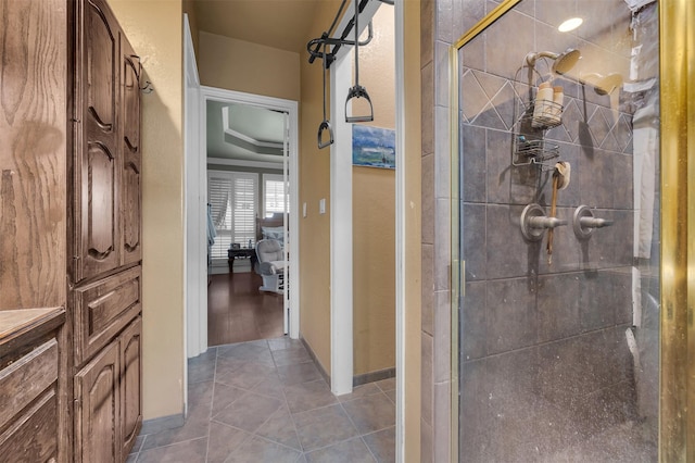 bathroom with a shower with door and tile patterned floors