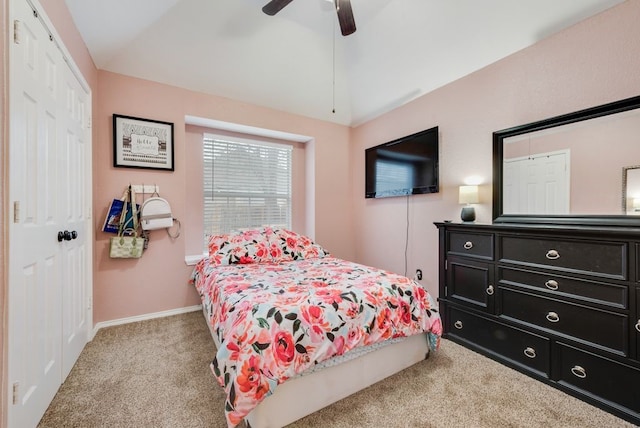 bedroom with lofted ceiling, light carpet, a closet, and ceiling fan