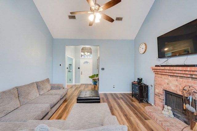 living room featuring ceiling fan, wood-type flooring, a fireplace, and vaulted ceiling