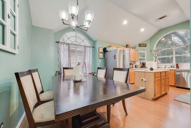 dining room with lofted ceiling, a notable chandelier, light hardwood / wood-style flooring, and a healthy amount of sunlight