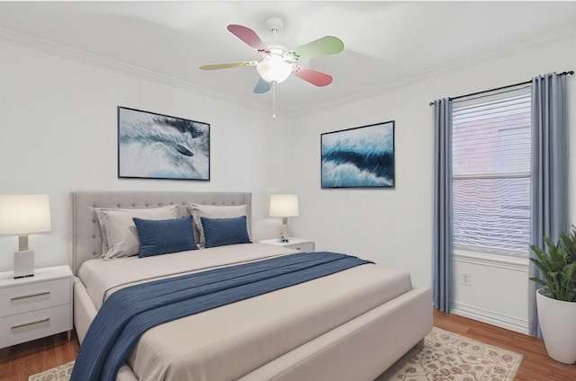 bedroom featuring crown molding, wood-type flooring, and ceiling fan