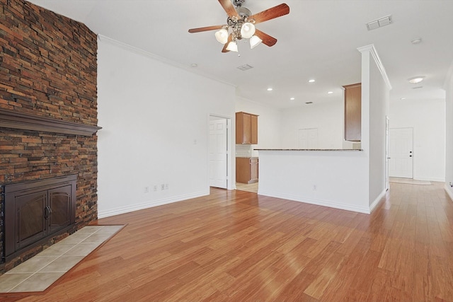 unfurnished living room featuring crown molding, ceiling fan, and light hardwood / wood-style floors