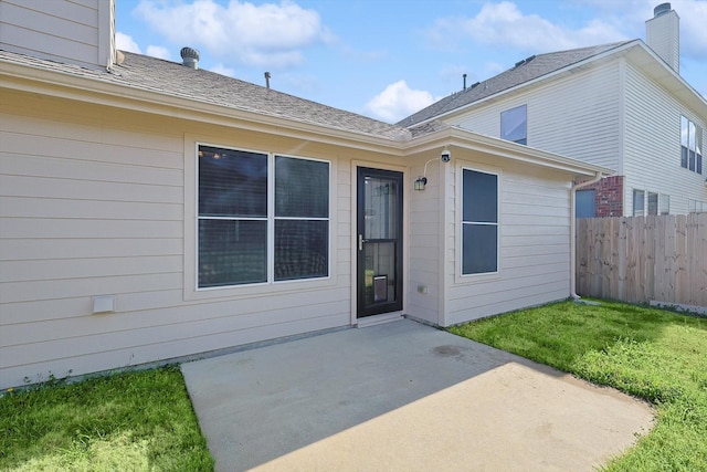 entrance to property with a lawn and a patio