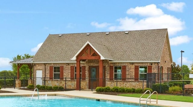 rear view of property featuring a community pool and a patio