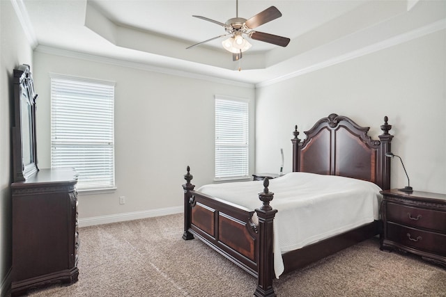 bedroom with ceiling fan, light colored carpet, ornamental molding, and a raised ceiling