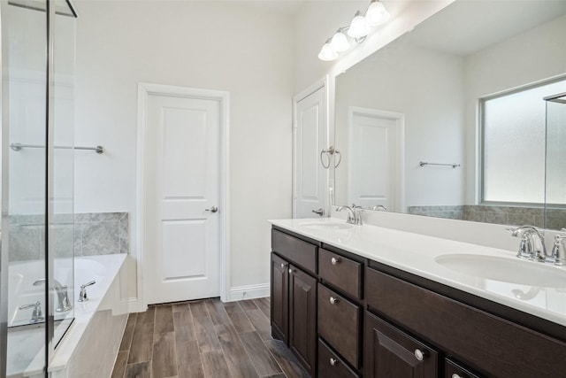 bathroom featuring hardwood / wood-style flooring, vanity, and a washtub