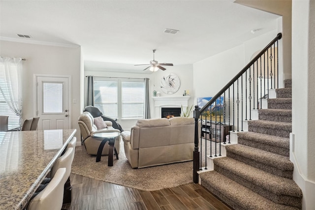 living room with crown molding, ceiling fan, and wood-type flooring