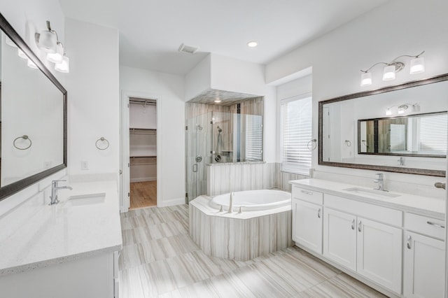 bathroom with vanity and shower with separate bathtub