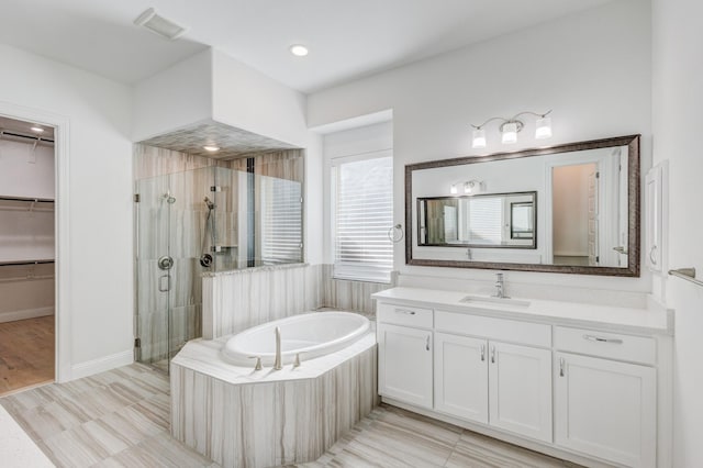 bathroom with vanity and separate shower and tub