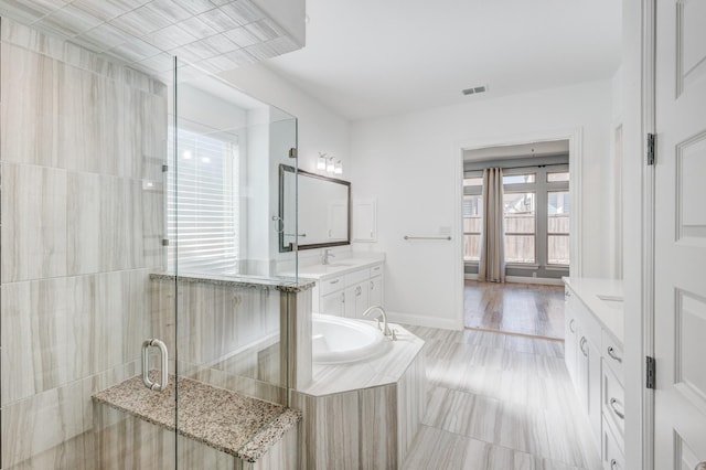 bathroom featuring vanity and separate shower and tub