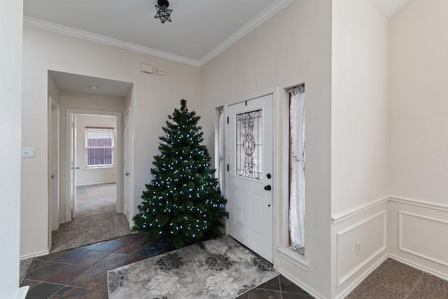 carpeted foyer entrance featuring crown molding