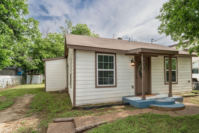 rear view of property featuring a lawn