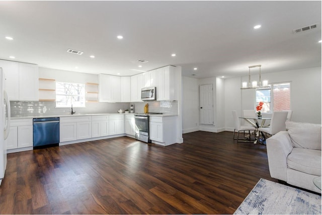 kitchen featuring white cabinetry, appliances with stainless steel finishes, and decorative light fixtures