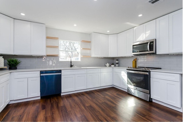 kitchen with sink, white cabinetry, backsplash, stainless steel appliances, and dark hardwood / wood-style flooring