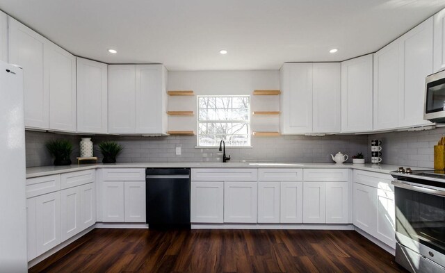 kitchen featuring stainless steel appliances, sink, dark wood-type flooring, and white cabinets