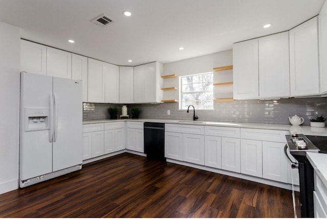 kitchen featuring electric stove, sink, dishwasher, white refrigerator with ice dispenser, and white cabinets