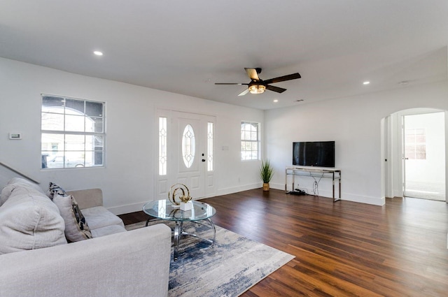 living room featuring ceiling fan and dark hardwood / wood-style floors