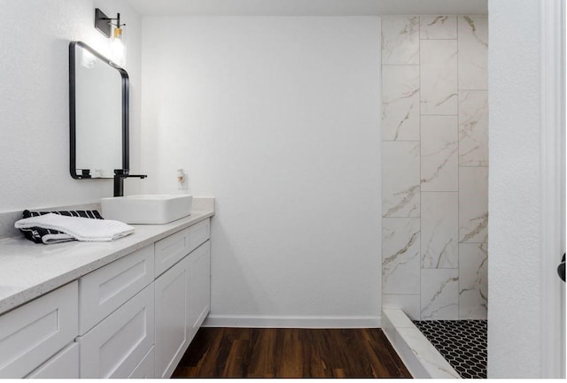 bathroom with a tile shower, hardwood / wood-style floors, and vanity