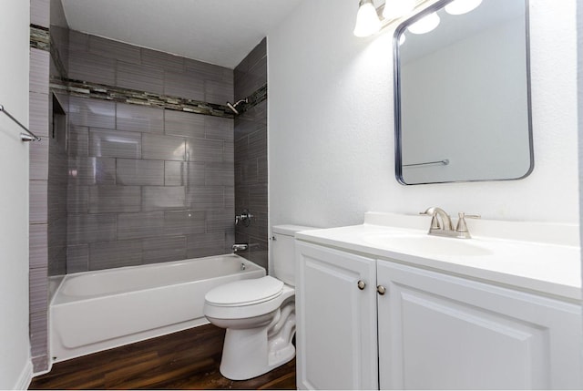 full bathroom with vanity, tiled shower / bath combo, wood-type flooring, and toilet