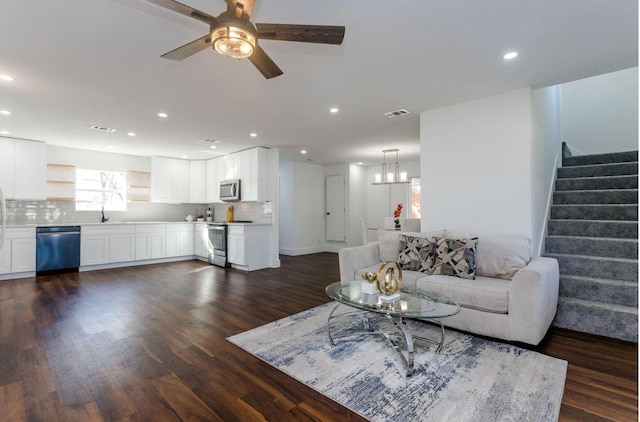 living room featuring dark hardwood / wood-style flooring, sink, and ceiling fan