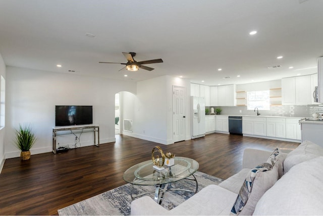 living room featuring ceiling fan, dark hardwood / wood-style flooring, and sink