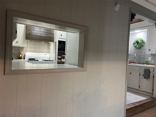 kitchen featuring white refrigerator, white cabinetry, wood ceiling, and decorative backsplash