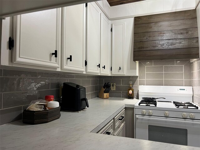 kitchen featuring tasteful backsplash, white cabinets, and white refrigerator