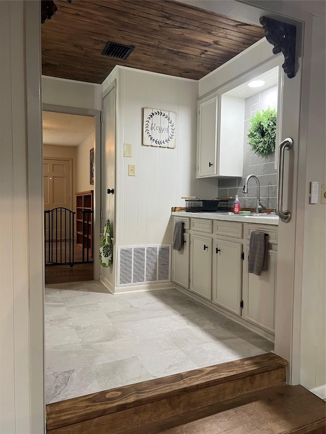 kitchen featuring tasteful backsplash, sink, wooden ceiling, and white cabinets