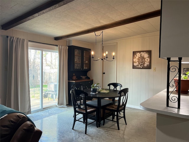 dining space featuring beam ceiling, finished concrete floors, baseboards, and a notable chandelier