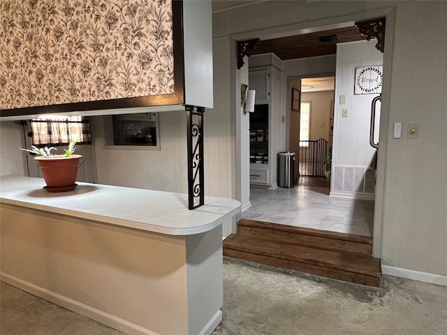 bar with unfinished concrete floors and baseboards