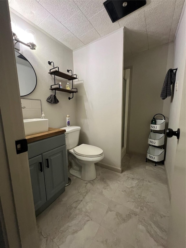 full bathroom with a shower stall, toilet, vanity, and baseboards