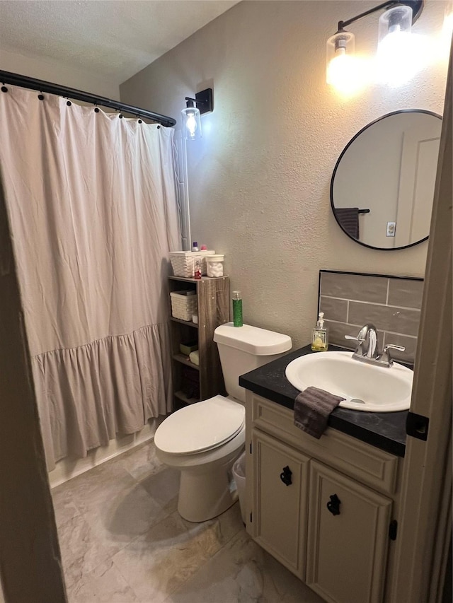 bathroom featuring a shower with curtain, toilet, tasteful backsplash, vanity, and a textured wall