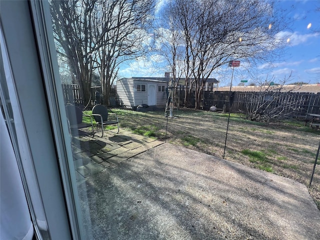 view of yard with a storage unit, a patio, an outdoor structure, and a fenced backyard