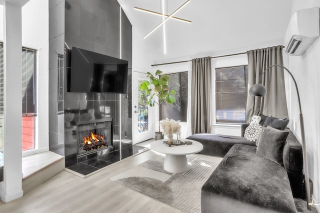 living room with hardwood / wood-style flooring, a fireplace, and a wall unit AC