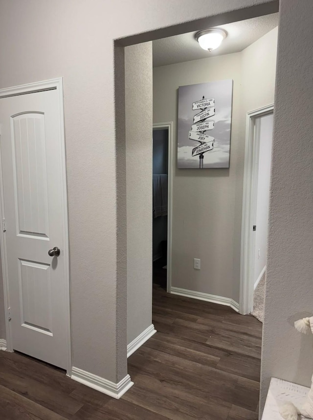 hall with dark hardwood / wood-style flooring and a textured ceiling