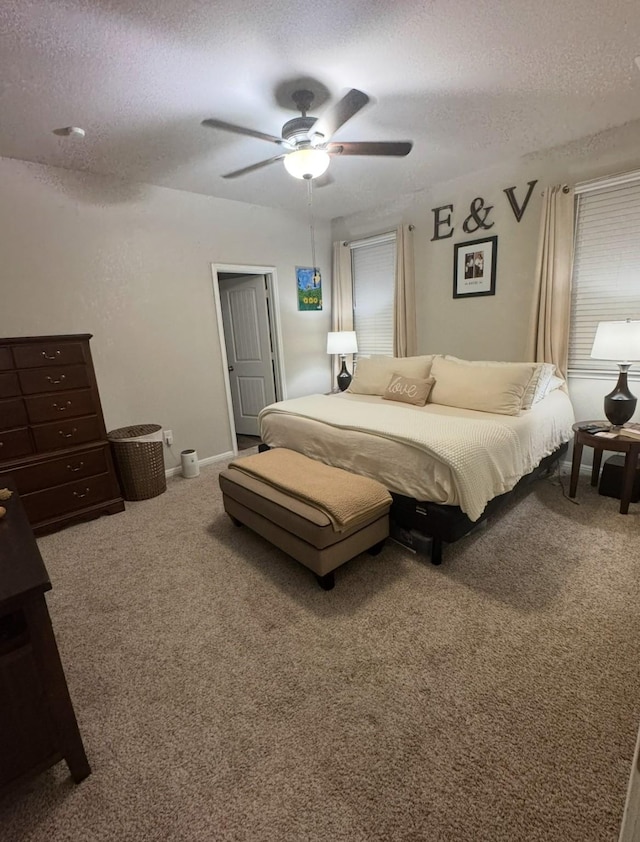 carpeted bedroom with ceiling fan and a textured ceiling