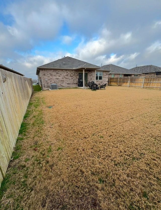 back of property with a yard and central air condition unit