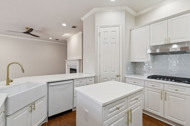 kitchen featuring white dishwasher, sink, white cabinetry, and a kitchen island