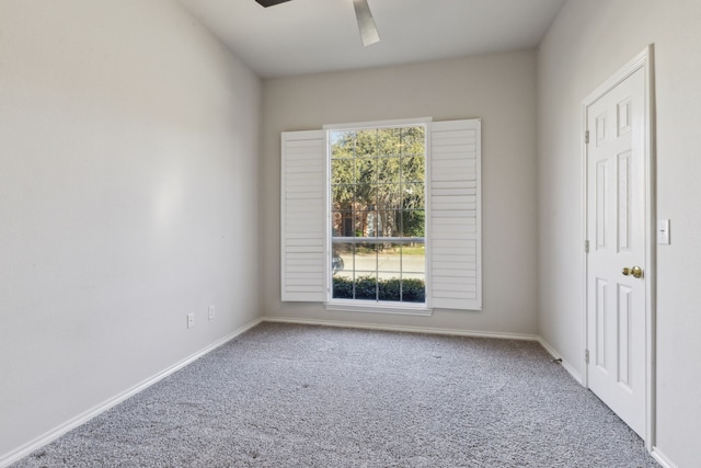 empty room featuring ceiling fan and carpet