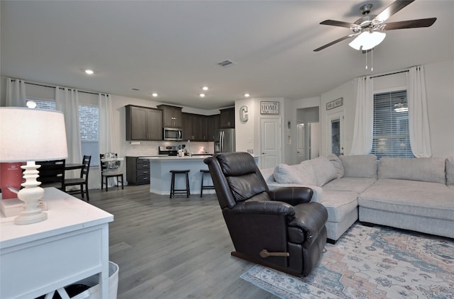 living room with wood-type flooring and ceiling fan