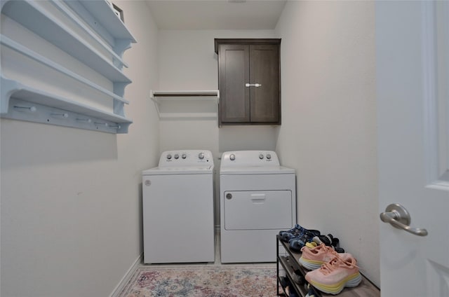 washroom with cabinets and washing machine and clothes dryer