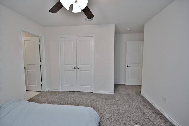 carpeted bedroom featuring a closet and ceiling fan