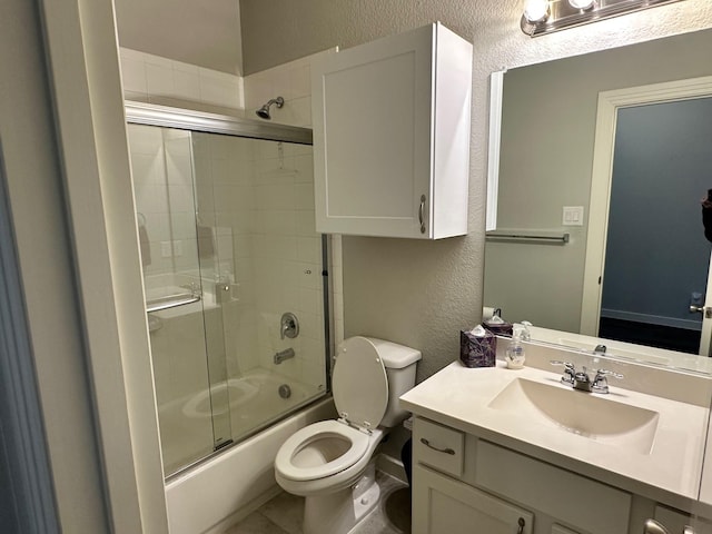 full bathroom featuring toilet, vanity, and shower / bath combination with glass door