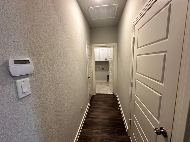 corridor with dark hardwood / wood-style flooring