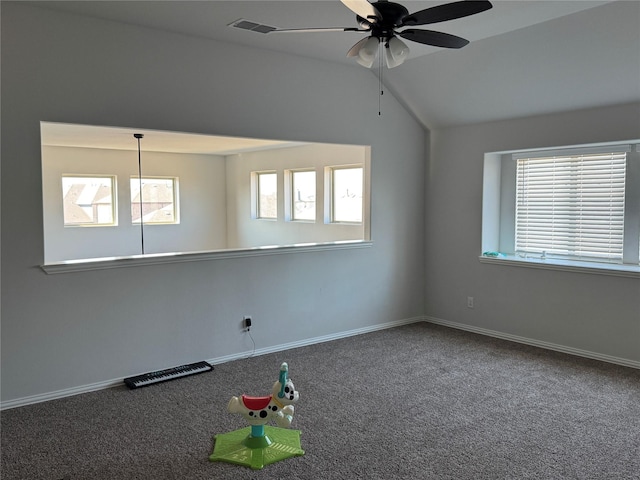 carpeted spare room featuring ceiling fan and vaulted ceiling