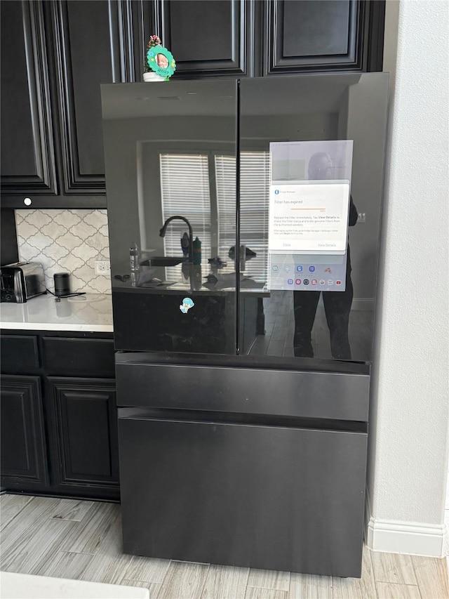 kitchen featuring tasteful backsplash and black fridge