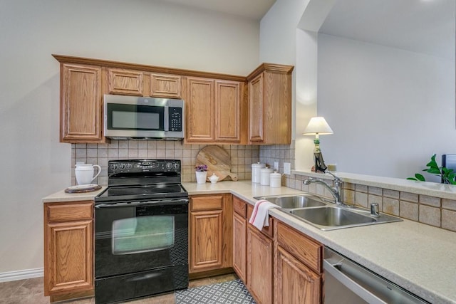 kitchen with tasteful backsplash, appliances with stainless steel finishes, and sink