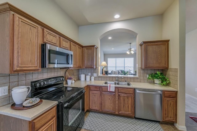 kitchen featuring stainless steel appliances, sink, light tile patterned floors, and backsplash